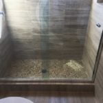 Pebble mosaic shower floor with woodlook tile walls installed by vincent provenzano